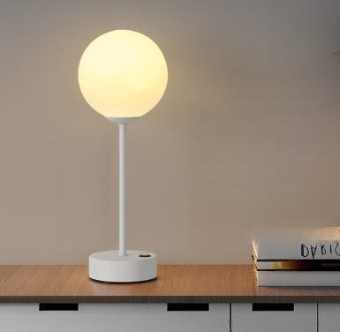 Aurum luminária sobre mesa de jantar ao lado de taças em ambiente noturno