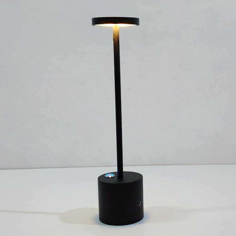 Luminária de mesa recarregável Mōva acesa sobre escrivaninha