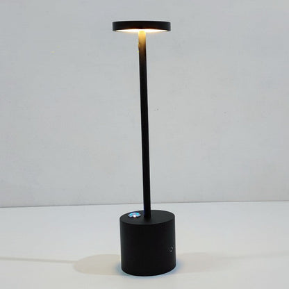 Luminária de mesa recarregável Mōva acesa sobre escrivaninha